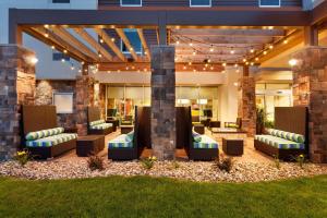an outdoor patio with couches and chairs and lights at Home2 Suites by Hilton Pittsburgh - McCandless, PA in McCandless Township