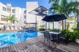 a table with an umbrella next to a swimming pool at Seven Boutique Unit #36 in Cancún