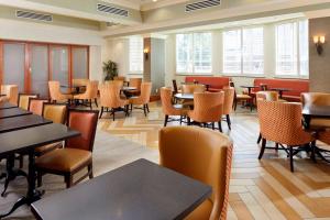 a dining room with tables and chairs and windows at Hampton Inn & Suites Savannah/Midtown in Savannah