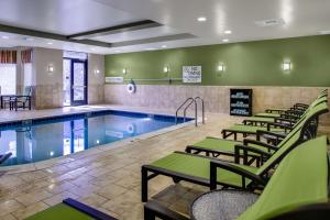 una piscina con una fila de sillas junto a ella en Hilton Garden Inn Pittsburgh/Cranberry, en Cranberry Township