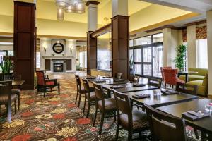 a restaurant with tables and chairs and a fireplace at Hilton Garden Inn Pittsburgh/Cranberry in Cranberry Township
