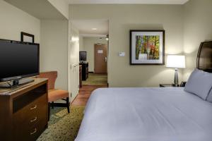 a hotel room with a bed and a flat screen tv at Hilton Garden Inn Pittsburgh/Cranberry in Cranberry Township