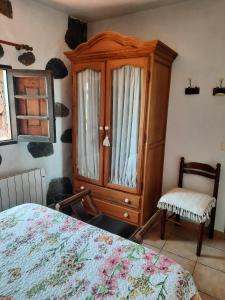 1 dormitorio con 1 cama y armario de madera en Casa Rural Sanjora, en Valverde