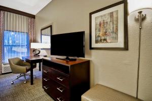 a hotel room with a desk with a flat screen tv at Hampton Inn Starkville in Starkville
