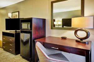 a hotel room with a desk and a mirror at Hampton Inn Starkville in Starkville