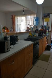 a kitchen with wooden cabinets and a stove top oven at Kingui in Santiago