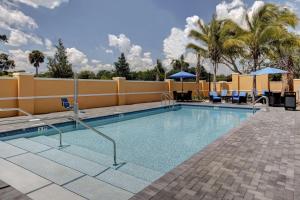 a swimming pool at a resort with palm trees at Hampton Inn and Suites by Hilton Vero Beach-Downtown in Vero Beach