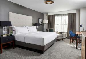 una camera d'albergo con un grande letto e una scrivania di Cumberland House Knoxville, Tapestry Collection by Hilton a Knoxville