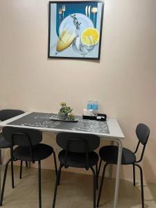 une table à manger avec des chaises et une photo sur le mur dans l'établissement studio condo building 81 newport boulevard, à Manille