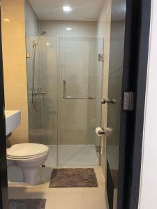 La salle de bains est pourvue d'une douche en verre et de toilettes. dans l'établissement studio condo building 81 newport boulevard, à Manille