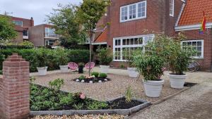 un jardín con macetas frente a un edificio en Cottage Jacob en Zandvoort