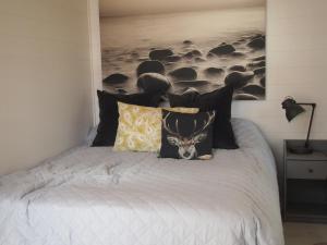 Suur AhvenkoskiSöderstrand B&B Pihlaja Room的一张带黑色枕头的床和一幅牛的画