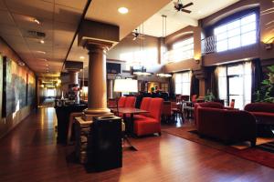 a lobby with red chairs and a bar at Hampton Inn & Suites Paso Robles in Paso Robles