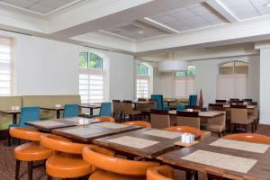 Hilton Garden Inn West Lafayette Wabash Landing في لافاييت: غرفة طعام مع طاولات وكراسي ونوافذ