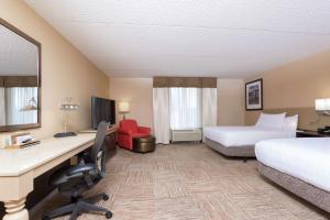a hotel room with two beds and a desk at Hilton Garden Inn West Lafayette Wabash Landing in Lafayette