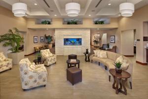 um átrio com sofás e cadeiras e uma lareira em Homewood Suites by Hilton Daytona Beach Speedway-Airport em Daytona Beach