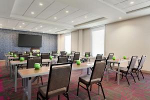 a conference room with tables and chairs and a projection screen at Home2 Suites By Hilton Silver Spring in Silver Spring