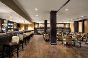 a restaurant with tables and chairs and a bar at DoubleTree by Hilton DFW Airport North in Irving