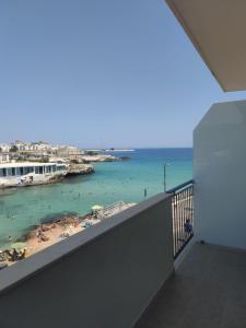 einen Balkon mit Blick auf den Strand und das Meer in der Unterkunft Sfumature D'aMare in Monopoli
