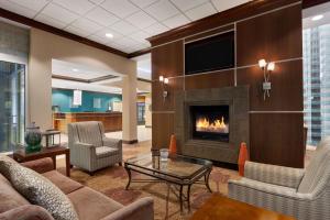 a living room with a fireplace and a tv at Hilton Garden Inn Dulles North in Ashburn