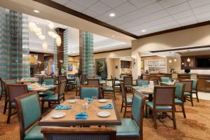a dining room with wooden tables and chairs at Hilton Garden Inn Dulles North in Ashburn