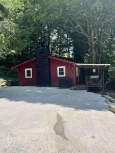 a red cabin with a chimney in front of it at Creekside 3 bedroom 2 bath cabin on private creek in Banner Elk