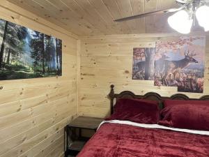 a bedroom with a bed and a painting of a deer at Creekside 3 bedroom 2 bath cabin on private creek in Banner Elk