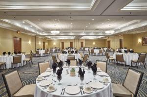 un salón de banquetes con mesas y sillas blancas en Hilton Knoxville, en Knoxville