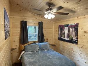 a bedroom with a bed and a ceiling fan at Creekside 3 bedroom 2 bath cabin on private creek in Banner Elk