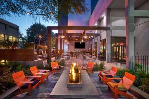 un patio con sillas naranjas y una hoguera frente a un edificio en Hilton Knoxville, en Knoxville