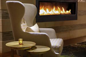 a fireplace in a living room with a chair and a table at DoubleTree by Hilton Fairfield Hotel & Suites in Fairfield