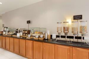 a buffet line with glasses and food on it at Embassy Suites Newark - Wilmington/South in Newark