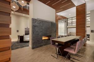 a dining room with a fireplace and a table and chairs at Homewood Suites Midtown Manhattan Times Square South in New York