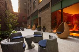 un groupe de chaises et de tabourets sur un trottoir dans l'établissement Homewood Suites Midtown Manhattan Times Square South, à New York