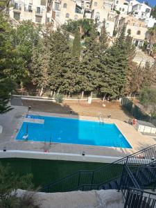 una gran piscina azul frente a algunos edificios en La estrella de Javi en Benajarafe