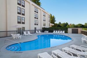 a hotel with a pool and chairs and a building at Hampton Inn Philadelphia/Mt. Laurel in Mount Laurel
