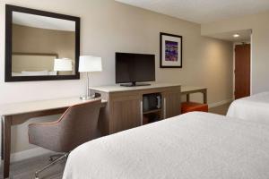 Habitación de hotel con cama y escritorio con TV. en Hampton Inn Philadelphia/Mt. Laurel, en Mount Laurel