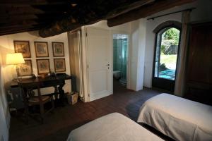 a bedroom with a bed and a desk and a window at Fattoria il Leccio Fienile on Florence Hills in Fiesole