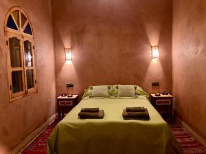1 dormitorio con 1 cama grande y 2 mesitas de noche en Riad Imuhar en Mhamid