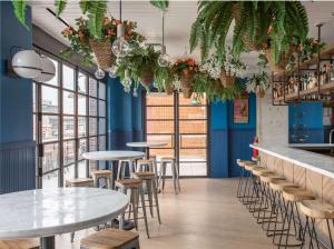 a restaurant with blue walls and tables and stools at Motto by Hilton Washington DC City Center in Washington