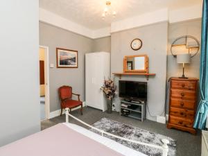 a bedroom with a bed and a tv and a chair at Flat 1 in Teignmouth