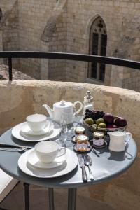 uma mesa com pratos, chávenas e taças de fruta em Hotel Porte Brunet em Saint-Émilion