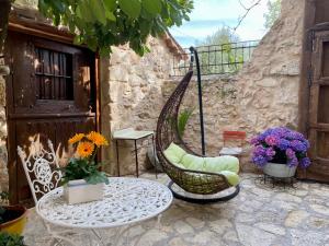 un patio con una silla, una mesa y flores en El Corral De Perorrubio en Perorrubio