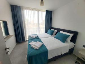 a bedroom with a large bed with blue and white pillows at Ethica Suite Luxury Houses in Aksu