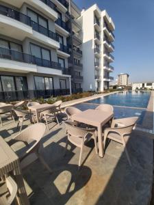 a patio with tables and chairs next to a swimming pool at Ethica Suite Luxury Houses in Aksu