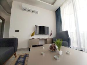 a living room with a table and a tv at Ethica Suite Luxury Houses in Aksu