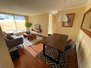 a living room with a dining room table and a couch at Departamento hermoso, 2 Dormitorios, 2 Baños con piscina, quincho y áreas verdes in Los Ángeles