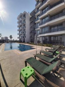 a swimming pool with chaise lounge chairs next to a building at Ethica Suite Luxury Houses in Aksu