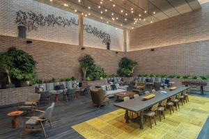 um restaurante com mesas e cadeiras e uma parede de tijolos em Canopy by Hilton Portland Pearl District em Portland