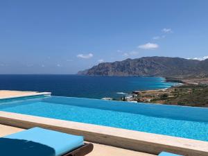 a swimming pool with a view of the ocean at Petra Nova Villas in Mochlos